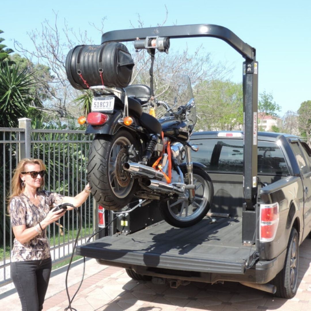 a person using the Impact 2000 to load a motorcycle into a truck bed