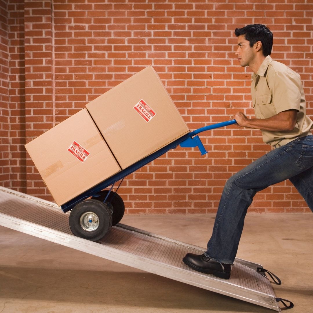 someone using a dolly to load heavy boxes