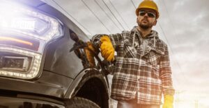 a worker in safety gear leaning on a truck